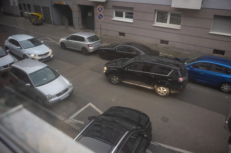 Beidseitig beparkte Straße, die in beide Richtungen befahren werden kann. Dabei kommen zwei Autos nicht aneinander vorbei.